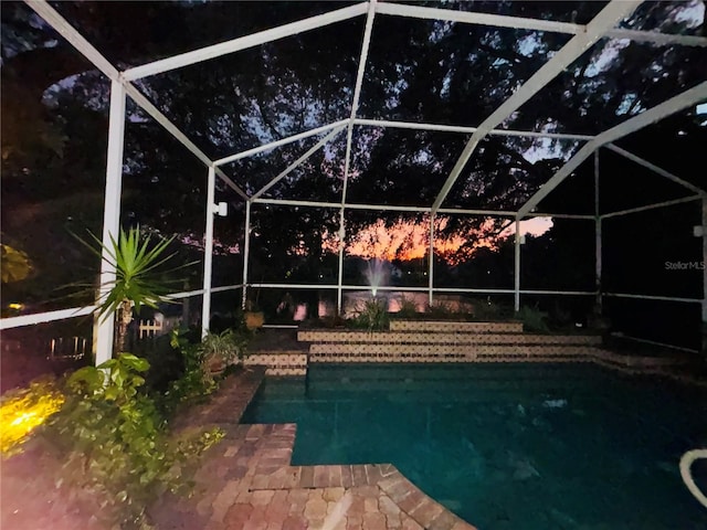 view of swimming pool featuring glass enclosure