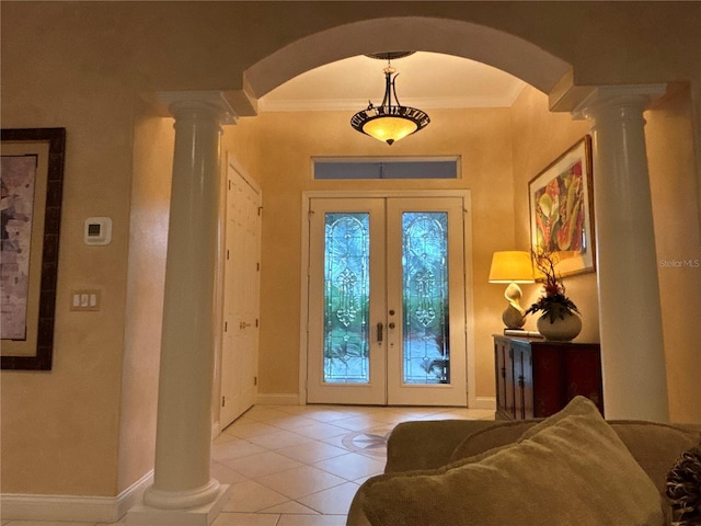 foyer with light tile patterned floors, french doors, ornamental molding, and ornate columns