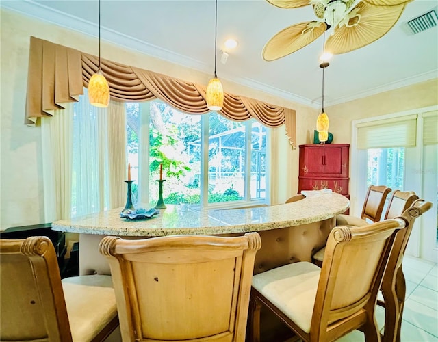 bar with hanging light fixtures, light tile patterned floors, ceiling fan, and ornamental molding