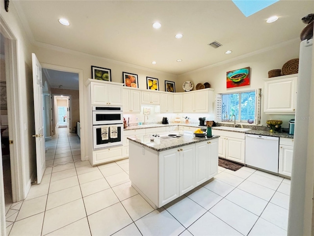 kitchen featuring white cabinets, light stone countertops, white appliances, and a center island