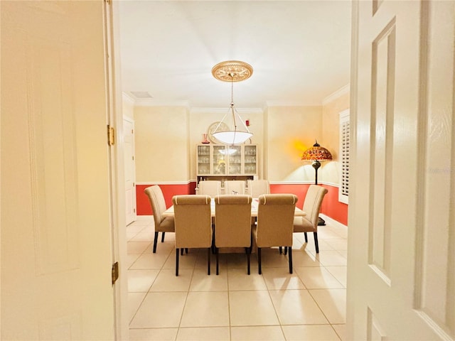 tiled dining area featuring ornamental molding