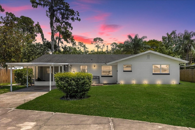 view of front of house featuring a carport and a lawn