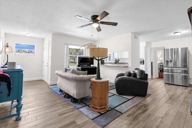 living room with ceiling fan and light hardwood / wood-style floors