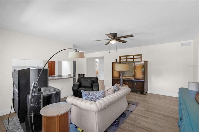 living room featuring ceiling fan and light hardwood / wood-style flooring