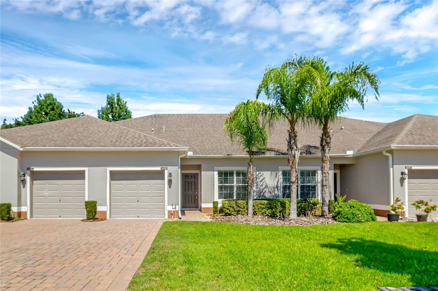 single story home with a garage and a front lawn