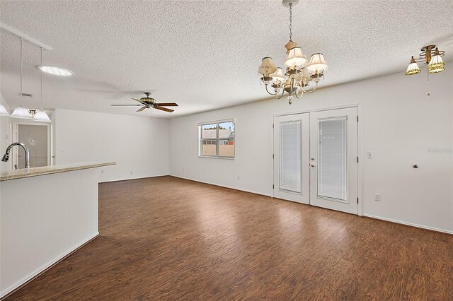 unfurnished living room featuring a textured ceiling, ceiling fan with notable chandelier, dark wood-type flooring, and sink