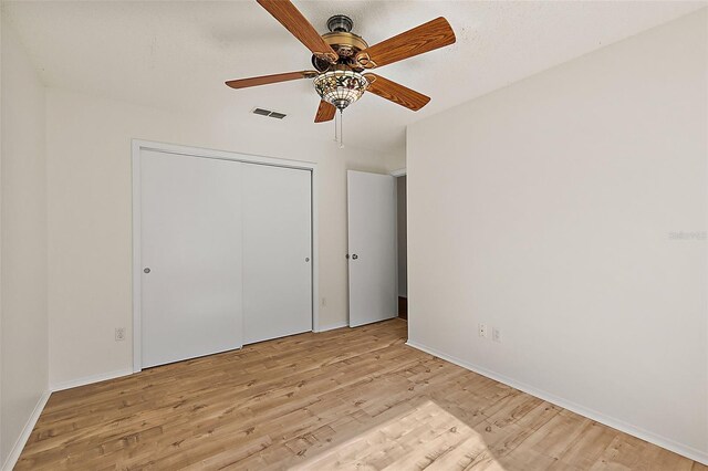 unfurnished bedroom featuring a closet, ceiling fan, and light hardwood / wood-style flooring