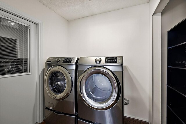 washroom with independent washer and dryer and a textured ceiling