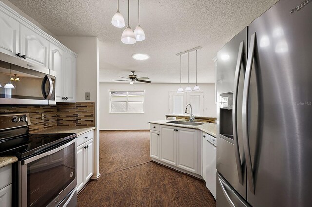 kitchen with white cabinets, decorative light fixtures, sink, and appliances with stainless steel finishes