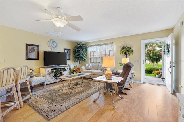 living room featuring light wood-type flooring and ceiling fan