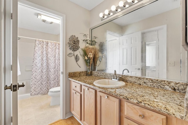 bathroom featuring vanity, tile patterned flooring, toilet, and walk in shower