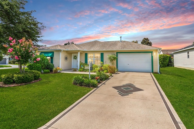 ranch-style home featuring a garage and a yard