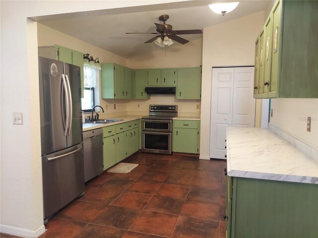 kitchen with under cabinet range hood, a sink, green cabinetry, and appliances with stainless steel finishes