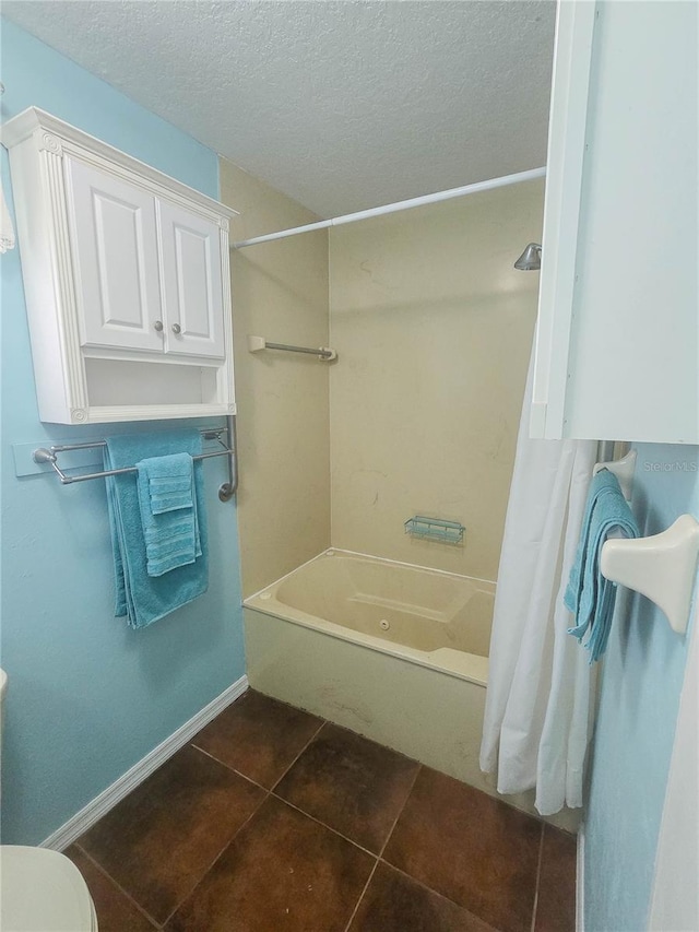bathroom featuring a textured ceiling, baseboards, toilet, tile patterned floors, and shower / tub combo with curtain