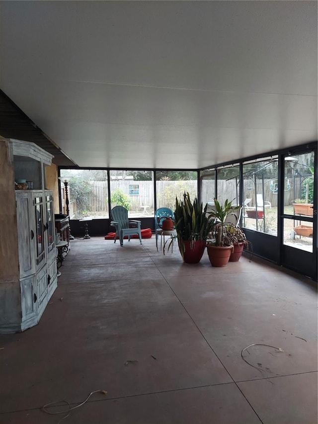 unfurnished sunroom featuring concrete flooring
