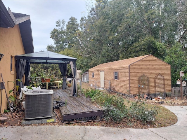 wooden terrace with fence, cooling unit, and a gazebo
