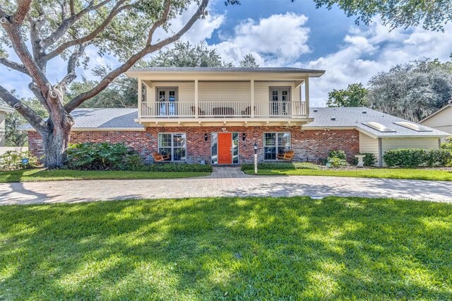 view of front of home featuring a balcony and a front yard