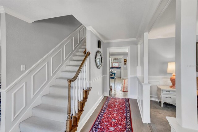 stairway featuring hardwood / wood-style flooring and ornamental molding