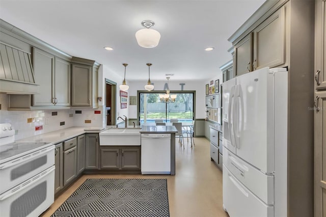 kitchen featuring decorative light fixtures, light countertops, decorative backsplash, white appliances, and a peninsula