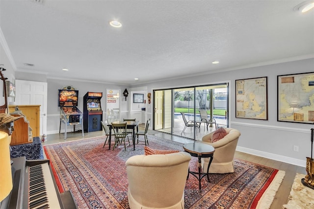 living room featuring a textured ceiling, ornamental molding, wood finished floors, and visible vents