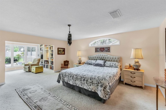 carpeted bedroom with visible vents, a textured ceiling, and baseboards