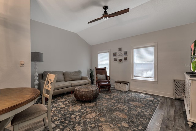 living room with dark hardwood / wood-style flooring, vaulted ceiling, and ceiling fan