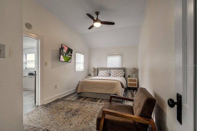 bedroom featuring multiple windows, ceiling fan, vaulted ceiling, and hardwood / wood-style flooring