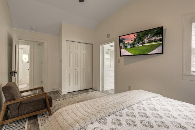 bedroom featuring a closet, light hardwood / wood-style floors, and vaulted ceiling