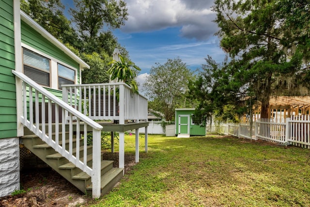 view of yard featuring a wooden deck and a storage unit