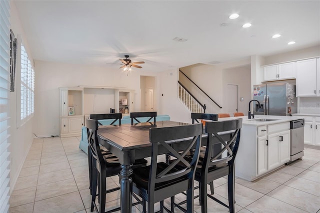 tiled dining area with ceiling fan and sink