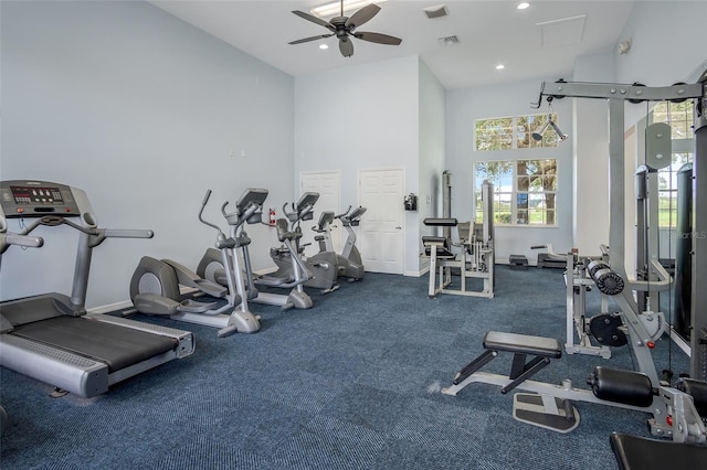 gym with ceiling fan and a towering ceiling