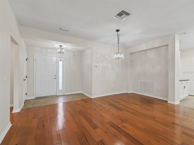 entrance foyer with light hardwood / wood-style flooring and an inviting chandelier