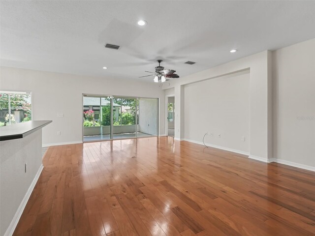 unfurnished living room featuring ceiling fan and hardwood / wood-style floors