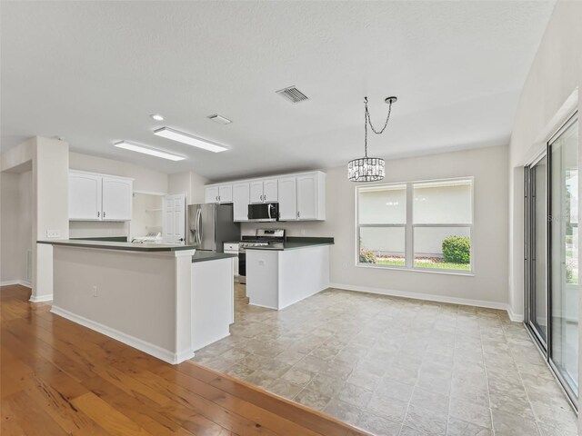 kitchen featuring white cabinets, kitchen peninsula, stainless steel appliances, and light hardwood / wood-style flooring