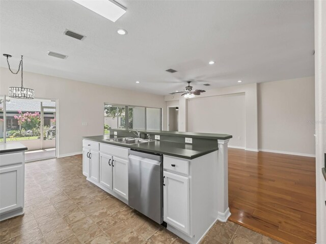 kitchen featuring white cabinetry, dishwasher, sink, pendant lighting, and ceiling fan with notable chandelier