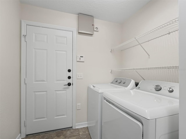 clothes washing area featuring washing machine and clothes dryer and a textured ceiling