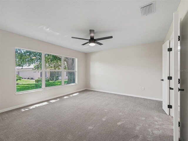 empty room featuring carpet floors and ceiling fan