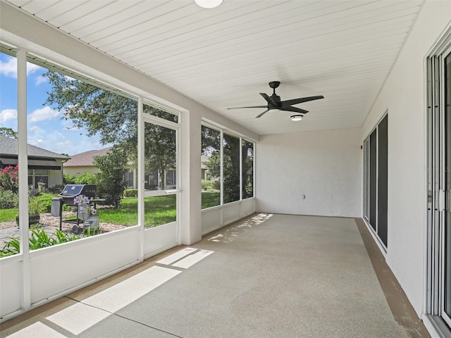 unfurnished sunroom with ceiling fan