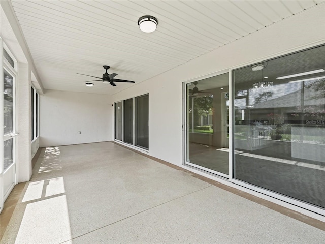 unfurnished sunroom featuring ceiling fan