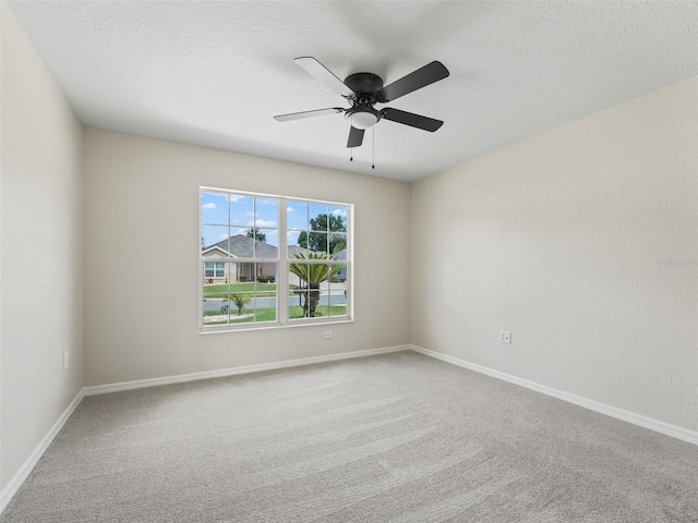 carpeted spare room featuring ceiling fan and a textured ceiling