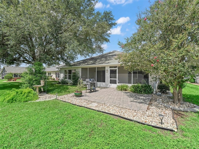 rear view of house with a sunroom, a patio area, and a yard