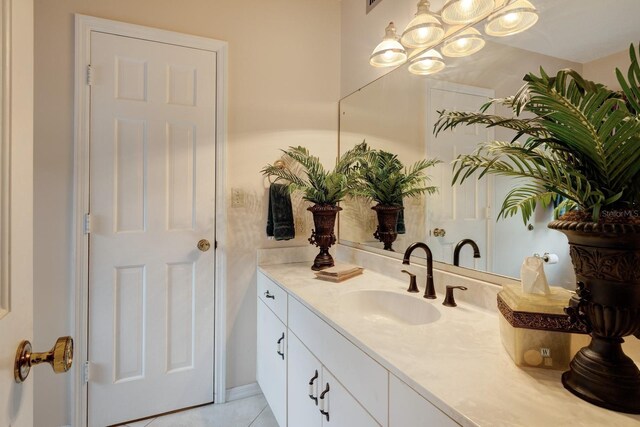 bathroom featuring a notable chandelier, vanity, and tile patterned floors