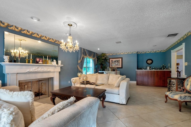 tiled living room featuring a chandelier and a textured ceiling