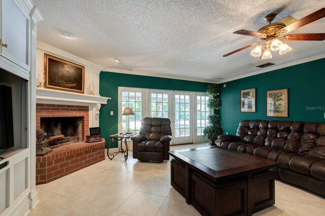 tiled living room with a textured ceiling, ornamental molding, a brick fireplace, and ceiling fan