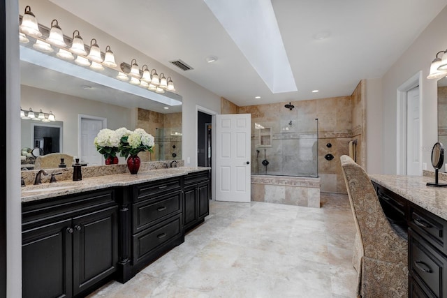 bathroom featuring tiled shower, vanity, and a skylight