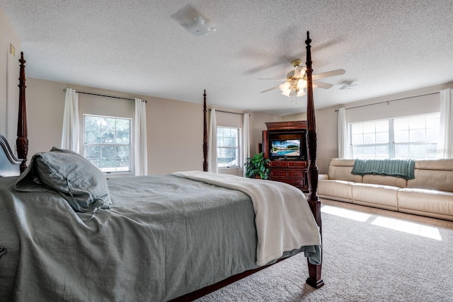 carpeted bedroom featuring a textured ceiling and ceiling fan