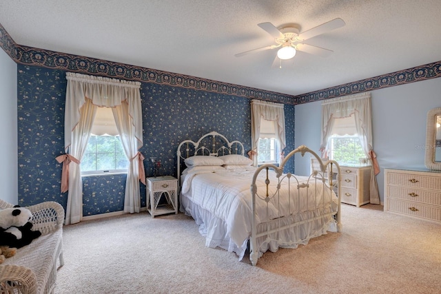 bedroom featuring multiple windows, light carpet, and a textured ceiling