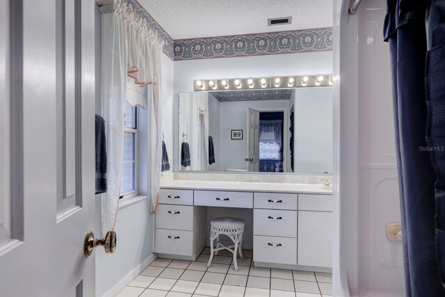 bathroom with tile patterned floors, a textured ceiling, and vanity