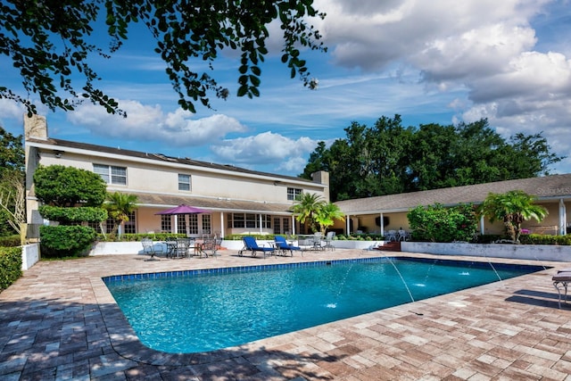 view of pool with a patio area and pool water feature