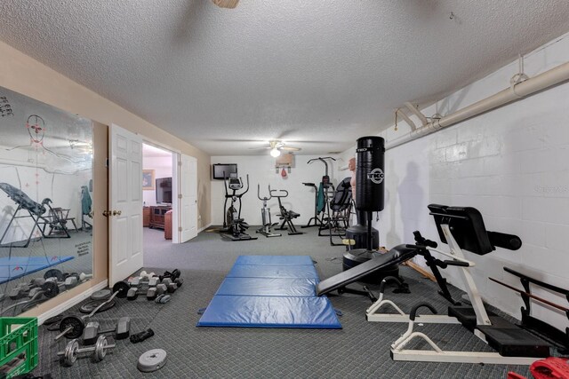 exercise room featuring a textured ceiling and carpet flooring